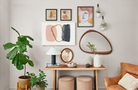 A room with a table , frames, chairs and a mirror